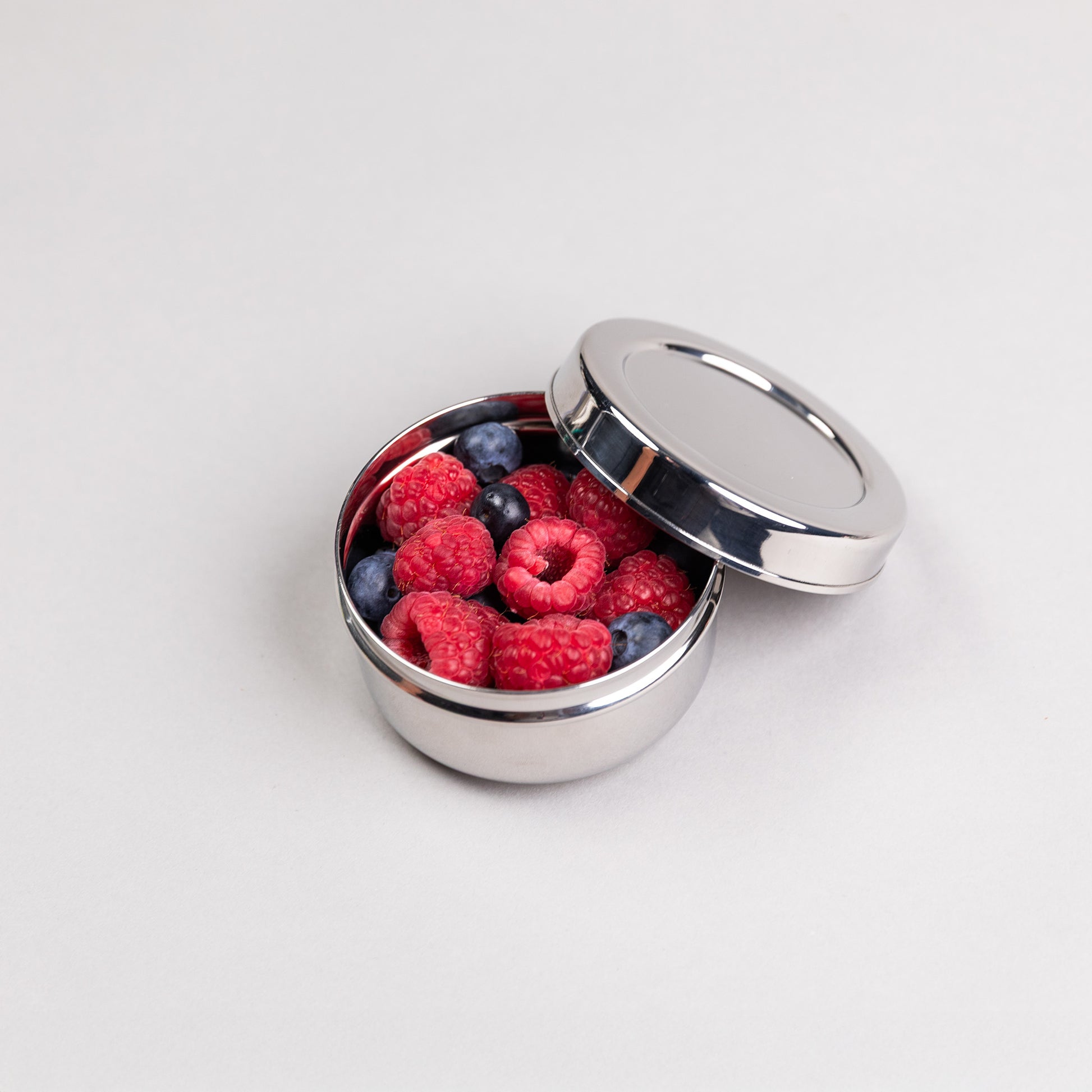 Medium RVS snackbox rond gevuld met frambozen.