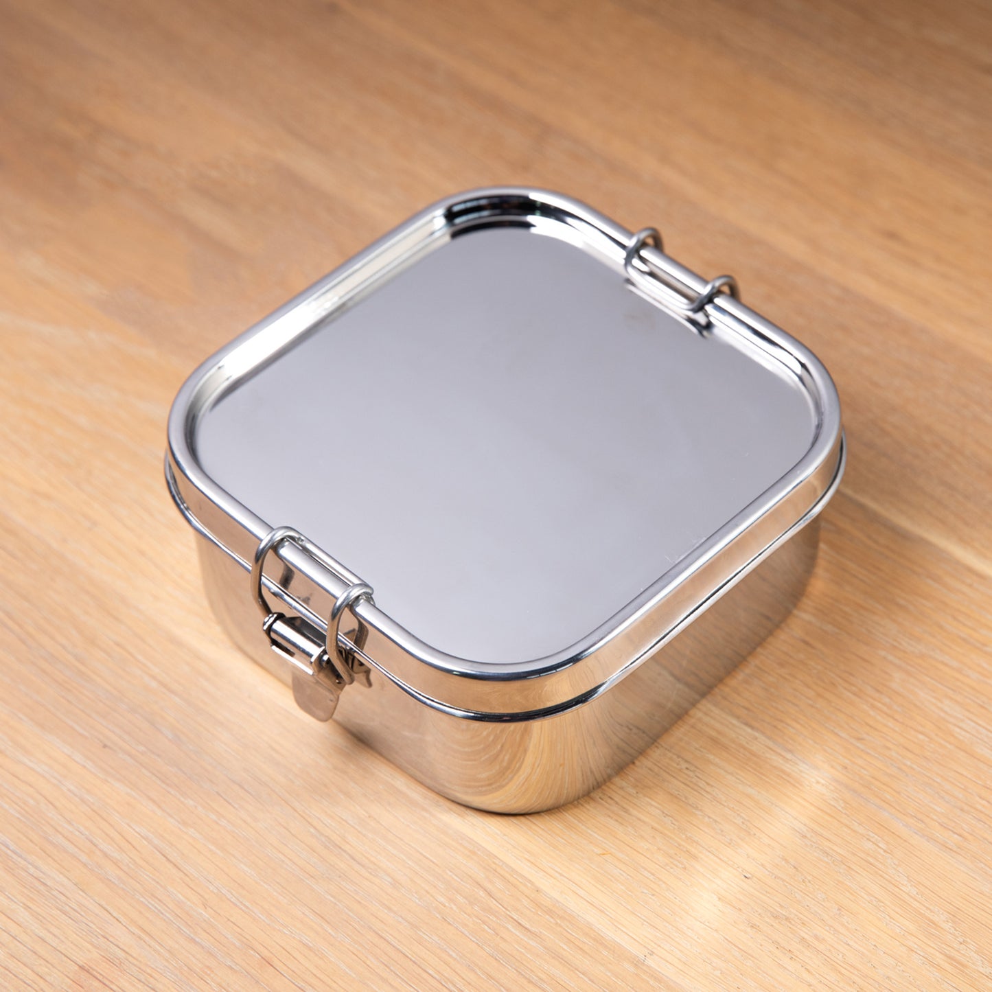 RVS lekvrije lunchbox op een houten ondergrond.