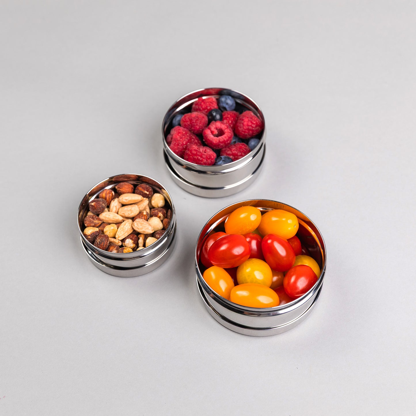 drie rvs snackboxen op een grijze achtergrond